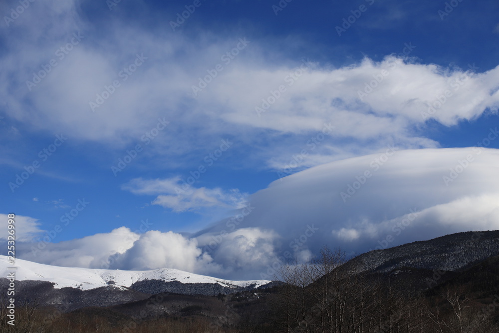 Snow-covered mountain in the Pyrenees covered with lenticular clouds, Aude in the southern France
