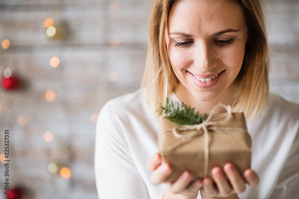 A young woman holding wrapped Christmas present. A young woman holding wrapped Christmas present.