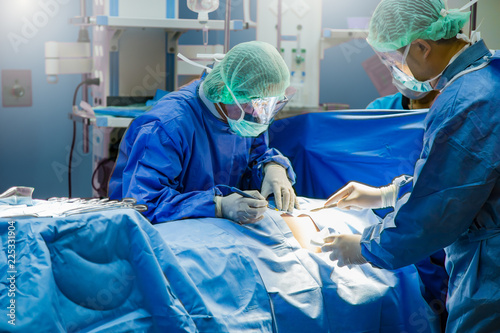 Several surgeons surrounding patient on operation table during their work.Medical team performing an operation in the surgery room, in a hospital.