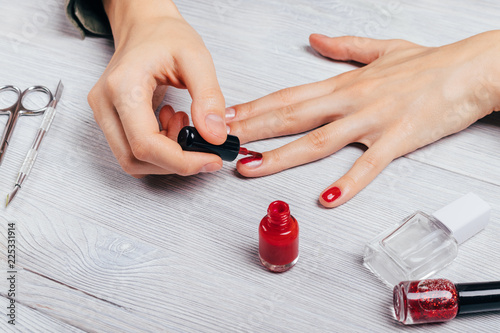 Close-up young woman does manicure to herself photo