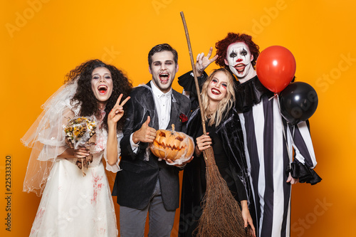 Group of cheerful friends dressed in scary costumes c