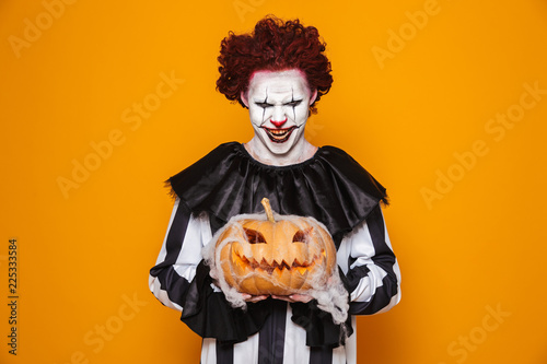 Mad man dressed in scary clown Halloween costume photo