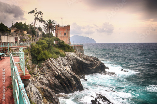 Stormy weather on the Tigullio gulf, view from the sea promenade  on the rocky coast of Genoa Nervi with the medieval Gropallo tower  built in the 16th-century as a watchtower for pirates. photo