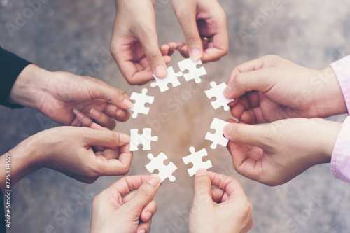 team hand placing the jigsaw puzzle piece for connect business partner and connection solution concept worker unity team.