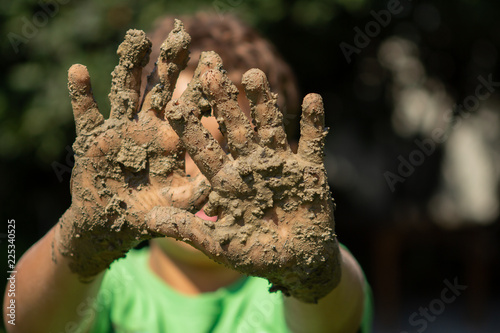 Kid plays outside in the mud