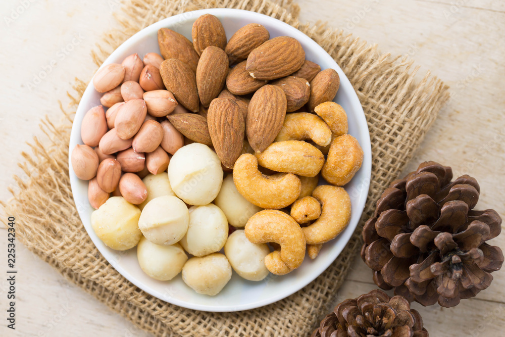 mixed nut, peanut almond macadamia and cashew nut on white plate, selective focus mixed nut, peanut almond macadamia and cashew nut on white plate, selective focus