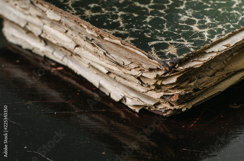 Ancient medieval worn books with yellow sheets stacked on a table