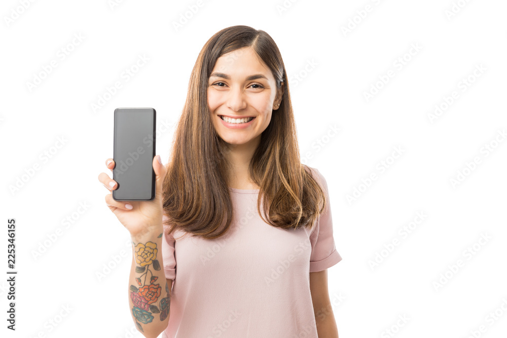 Pretty Female Smiling And Presenting Her New Mobile Phone Pretty Female Smiling And Presenting Her New Mobile Phone