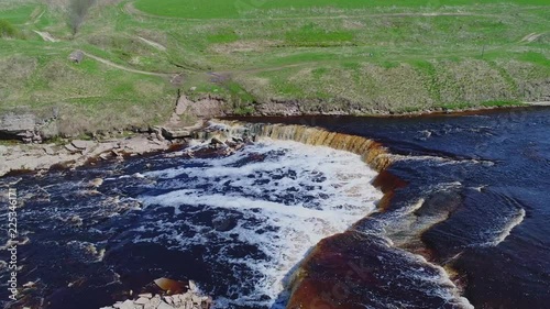 Over Gertowsky waterfall, Sunny may day (aerial video). Leningrad region, Russia photo