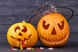 Halloween pumpkins on dark wooden background. Halloween holiday composition. Halloween decoration ideas.