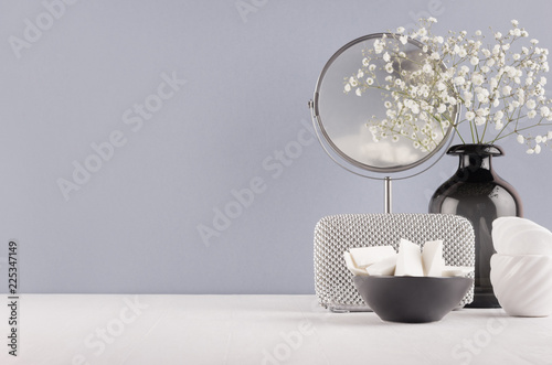 Canvas Print Perfect stylish decoration for home in grey colors - black glass vase with small fluffy flowers, mirror, female silver cosmetic bag, bowl sponges on soft ligth white wood table