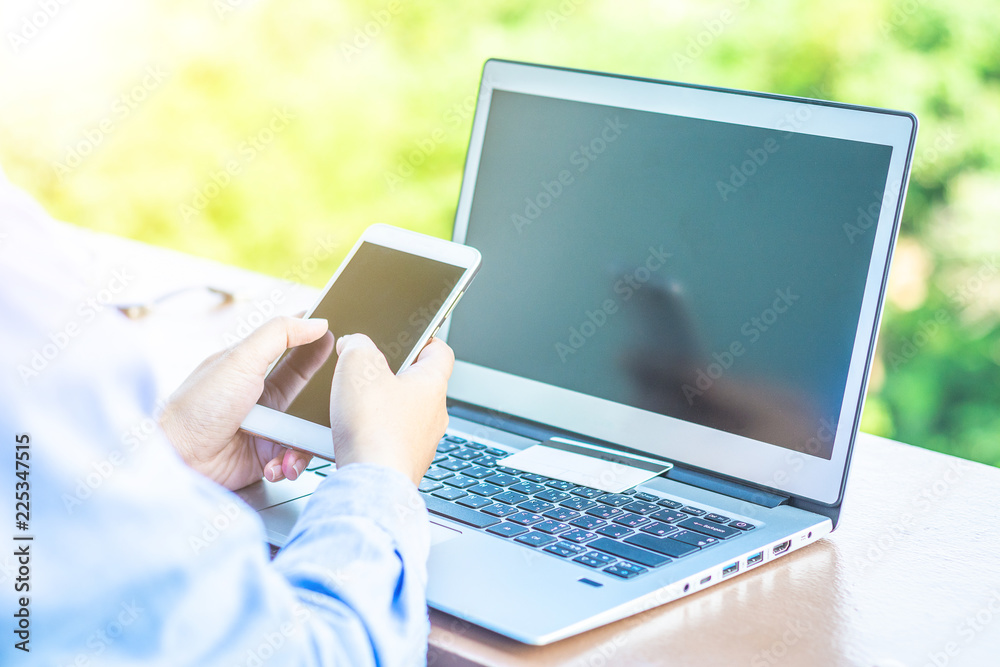 Fototapeta premium Man's hands holding a credit card and using laptop for online shopping.