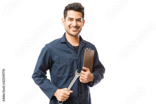 Smiling Male Repairman Holding Wrench And Clipboard