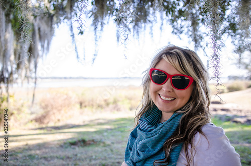 Female adult portrait of a blonde Caucasian woman looking at Spanish Moss in Beaufort, South Carolina photo