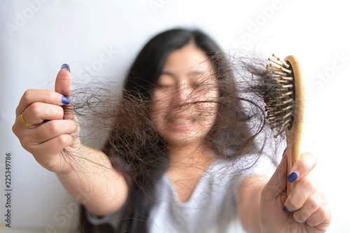 Hair loss, hair fall everyday serious problem, girl with a comb and problem hair on white background.