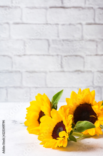 Fototapeta Naklejka Na Ścianę i Meble -  Background with fresh yellow sunflowers on a white kitchen table
