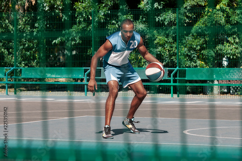 Picture of young confused african basketball player practicing outdoor. Fit afro man in motion and movement. athletic and sport lifestyle concept