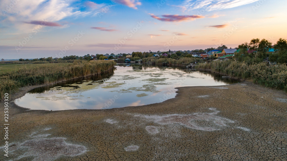 Dry the river near the village in the fall at sunset. Almost drought