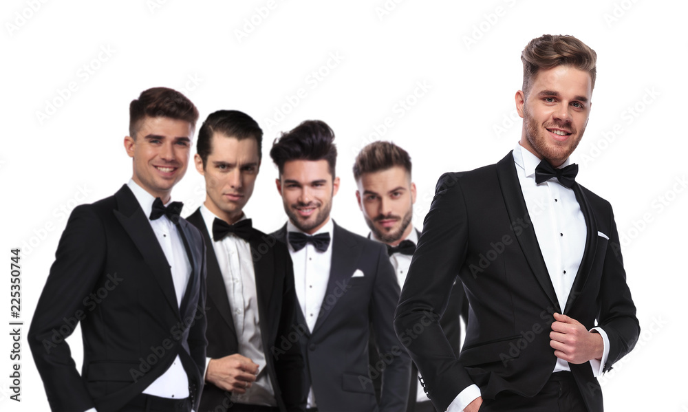 portrait of four men in tuxedoes in line with leader portrait of four men in tuxedoes in line with leader