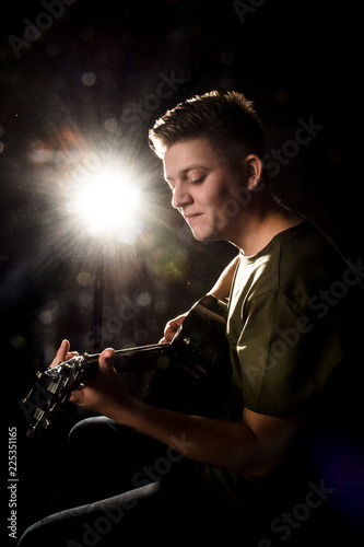 Guy in studio play on acoustic guitar
