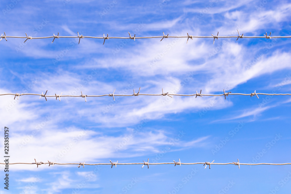 barbed wire on the background of the blue sky barbed wire on the background of the blue sky