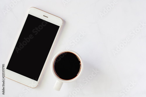 Smartphone with cup of blac...