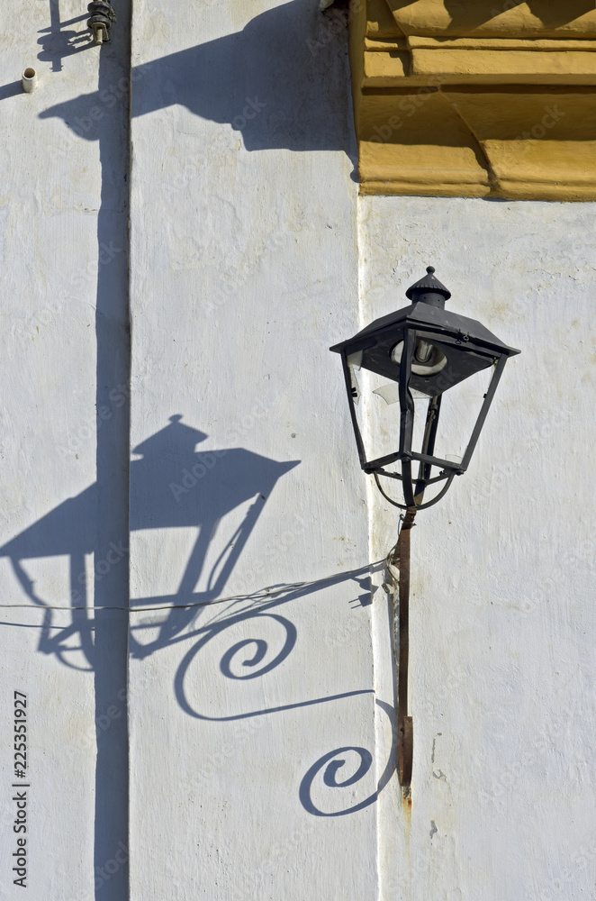 Old lamp with shadow on the white wall