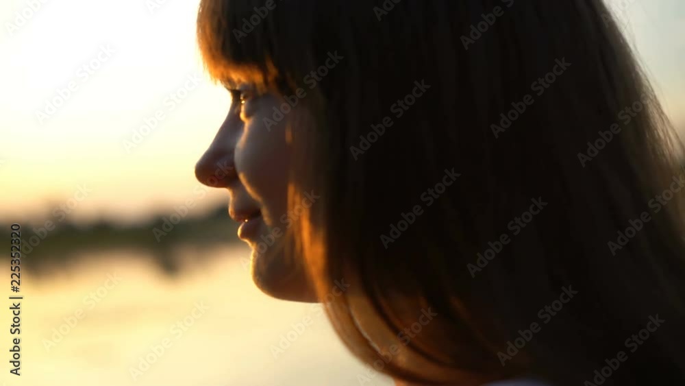 Young pretty woman alone at sunset, looking at sky, smiling shyly, loneliness Young pretty woman alone at sunset, looking at sky, smiling shyly, loneliness