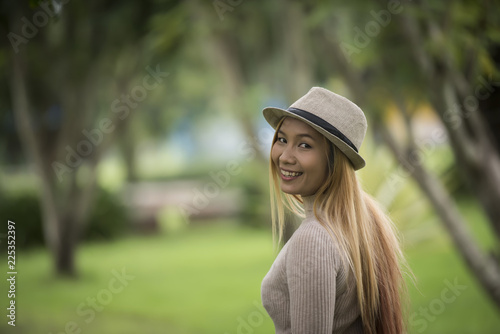 Attractive young woman enjoying her time outside in park with nature park background.
