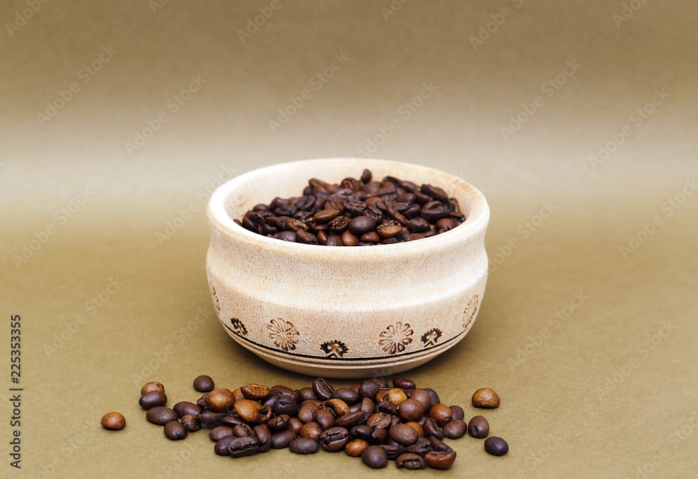 Coffee beans in a wooden cup. Coffee beans are scattered all over the city, close-up. Coffee beans in a wooden cup. Coffee beans are scattered all over the city, close-up.