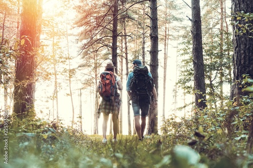 Tough route. Beautiful young couple hiking together in the woods while enjoying their journey.