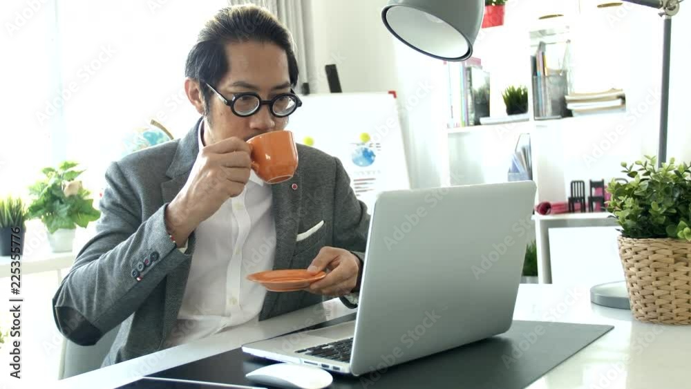 Businessman working on laptop computer in the office, 4K Slow motion asian business man wearing eyeglass in office.