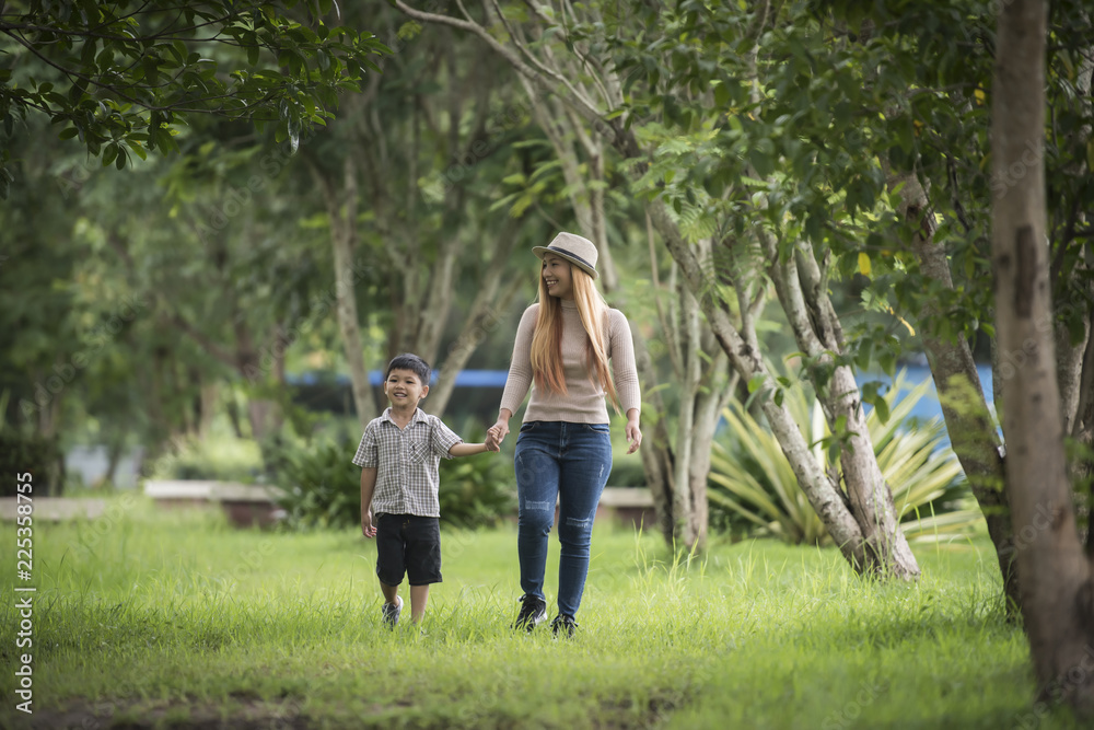 Portrait of mother and son happy walking together in the park holding hand. Family concept.