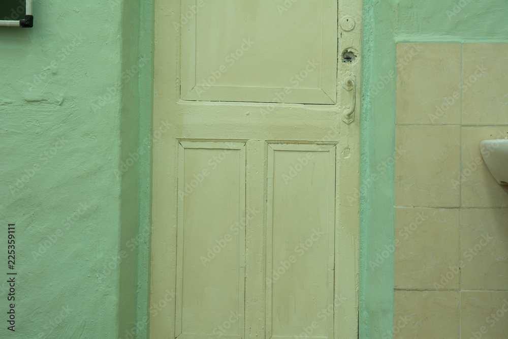 Background is an old white door and a green plaster wall Background is an old white door and a green plaster wall