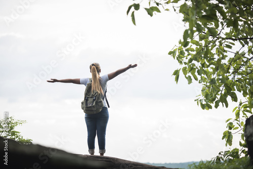Tourist girl with arms happy with nature near the river. Travel concept.