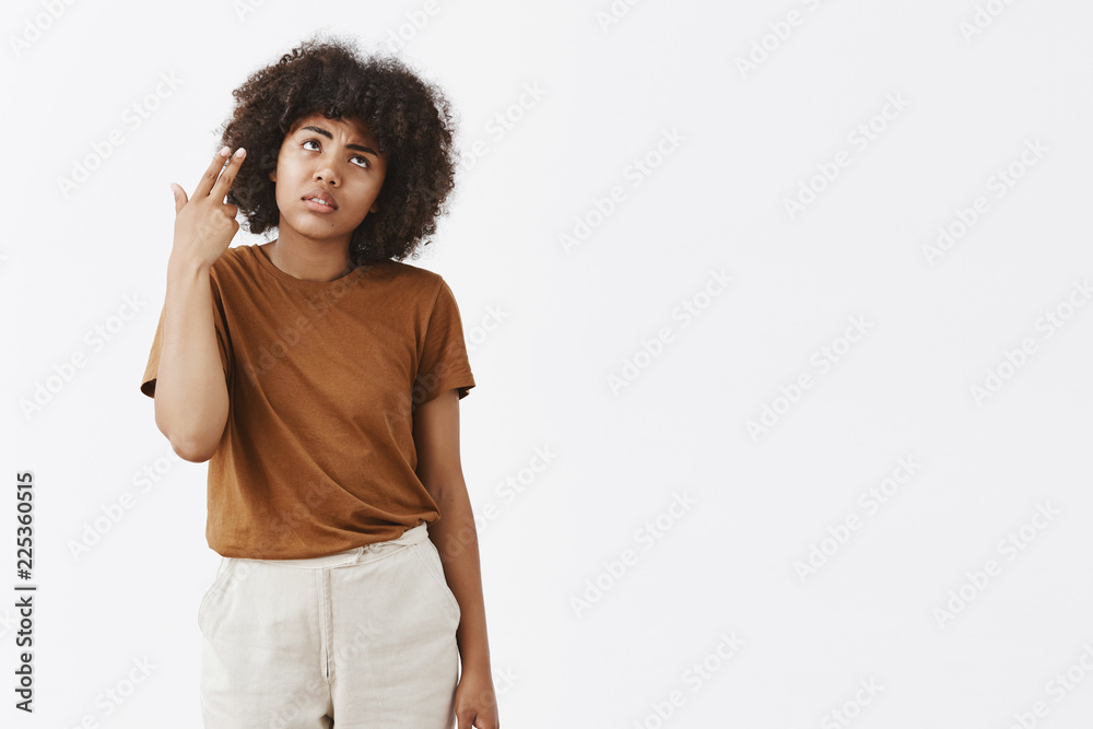 You killing me with boring talks. Gloomy dissatisfied African American girl with curly hairstyle in brown t-shirt dying from boredom and annoyance rolling eyelids making finger gun shooting in head You killing me with boring talks. Gloomy dissatisfied African American girl with curly hairstyle in brown t-shirt dying from boredom and annoyance rolling eyelids making finger gun shooting in head