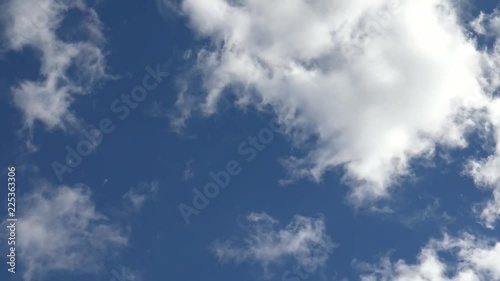 Time lapse clip of white fluffy clouds over blue sky
