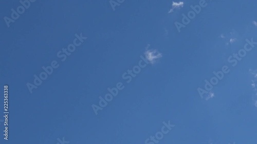 Time lapse clip of white fluffy clouds over blue sky