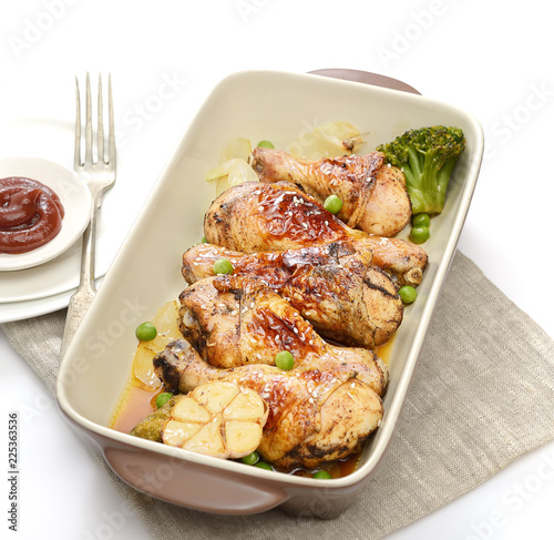 grilled chicken legs with sesame in a plate on a white background