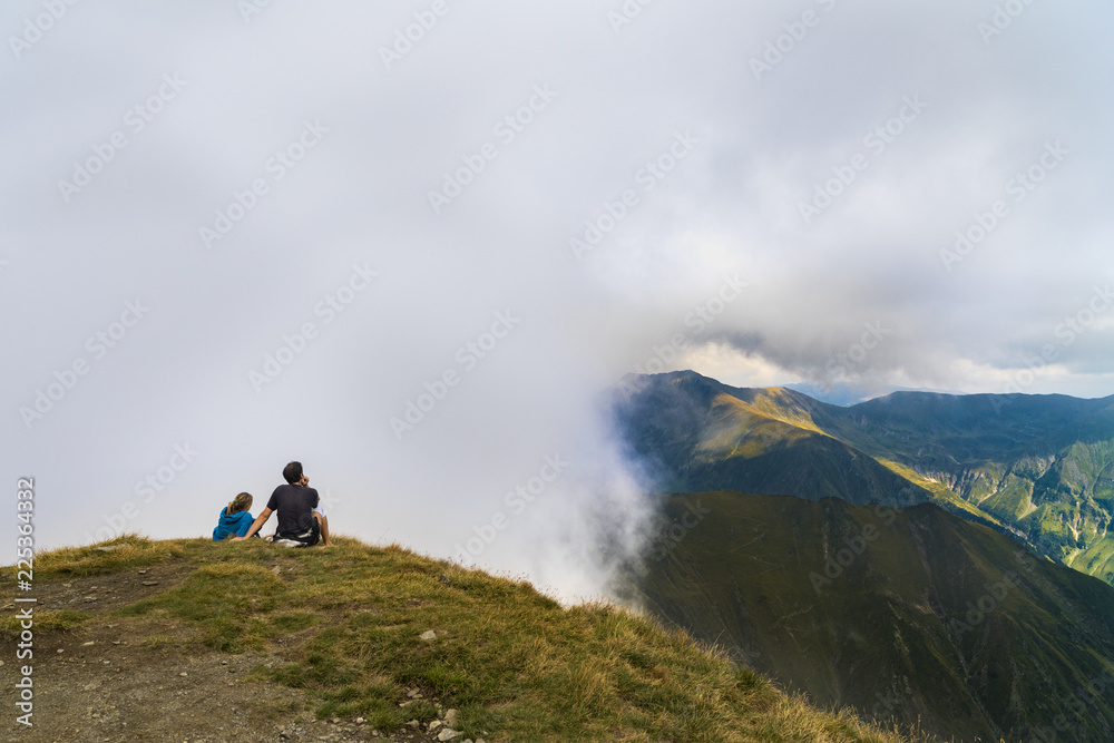 Young couple traveler standing and looking at beautiful landscape on top of mountain