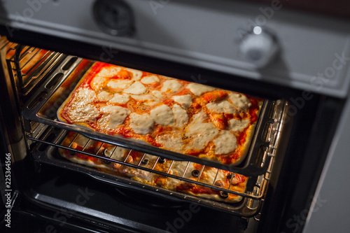 horizontal image of homemade pizzas while baking in the oven