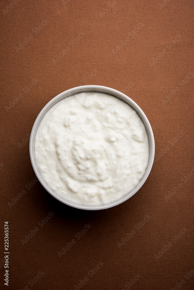 Plain curd or yogurt or Dahi in Hindi, served in a bowl over moody background. Selective focus Plain curd or yogurt or Dahi in Hindi, served in a bowl over moody background. Selective focus