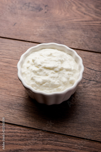 Plain curd or yogurt or Dahi in Hindi, served in a bowl over moody background. Selective focus