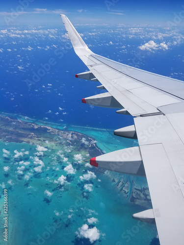 Airplane wing view above the Caribbean sea.