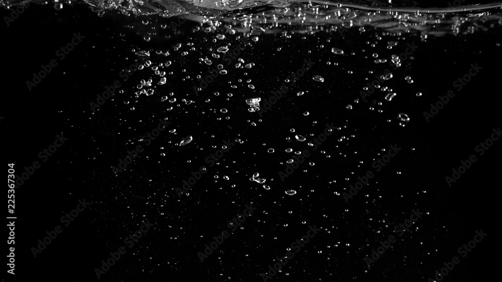 Water bubbles floating on black background which represent refreshing of refreshment from soda or carbonated drink and power of liquid that splashing or fizzing with blowing and streaming by air pump.