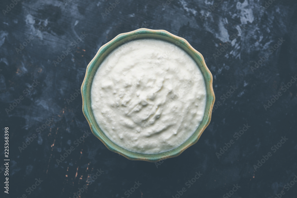 Plain curd or yogurt or Dahi in Hindi, served in a bowl over moody background. Selective focus Plain curd or yogurt or Dahi in Hindi, served in a bowl over moody background. Selective focus