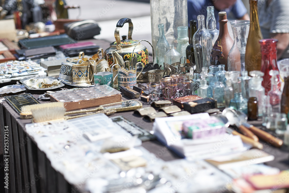 Market boot with objects beeing selled at the weekend flea market in the city center. Curious visitors in the background Market boot with objects beeing selled at the weekend flea market in the city center. Curious visitors in the background