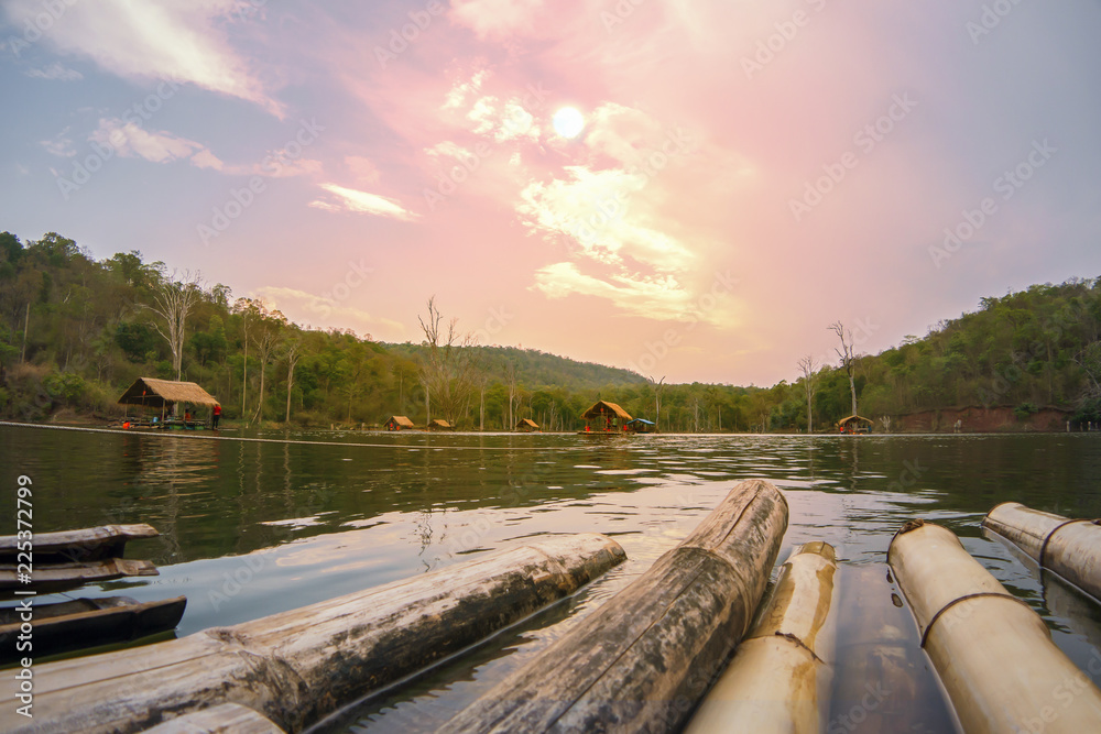Fototapeta premium Rafting bamboo on river mountain sunset sky and cloud