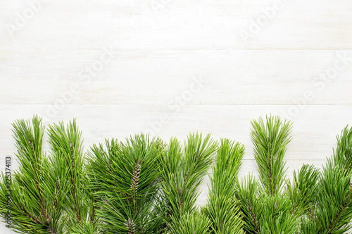 Christmas background, green pine branches on white wooden table. Creative composition with border and copy space design top view. New Year's, holiday, christmas, decoration