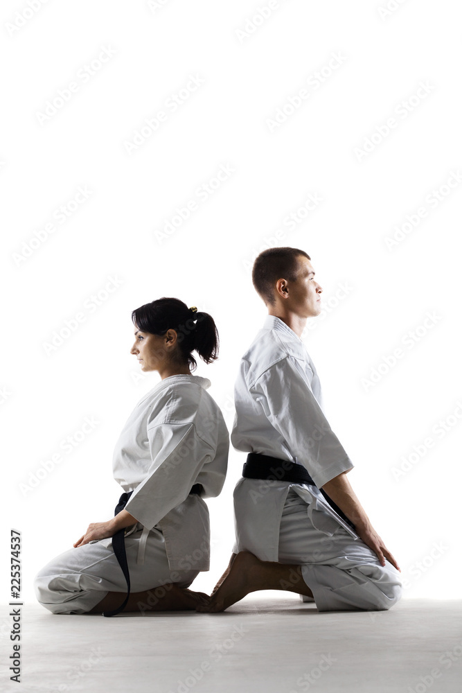 karate girl and boy sitting against white background karate girl and boy sitting against white background